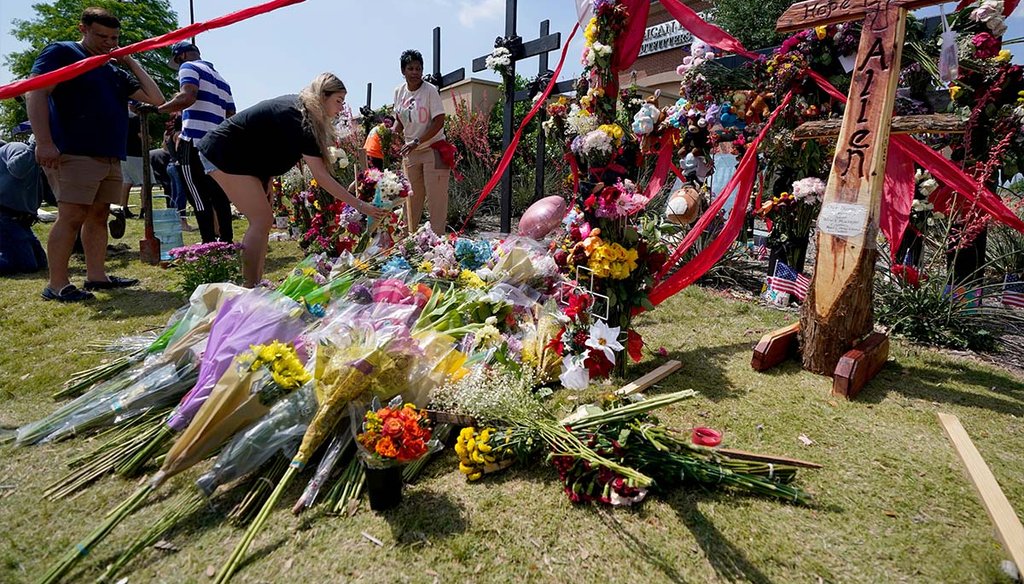 Visitors to a makeshift memorial leave flowers May 8, 2023 in front of a large cross engraved with the words “Hope, Love, Allen” at an Allen, Texas, outlet mall where several people were killed May 6, 2023. (AP)