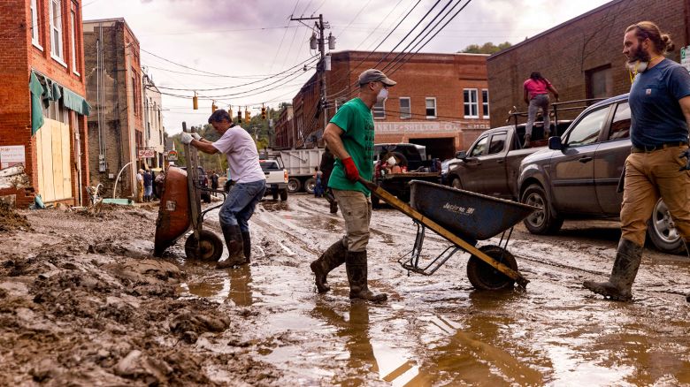 Residents and volunteers clean up on Tuesday, Oct. 1, 2024, after the French Broad River flooded downtown Marshall, North Carolina. The remnants of Hurricane Helene caused widespread flooding, downed trees, and power outages in western North Carolina. (Travis Long/The News & Observer/Tribune News Service via Getty Images)